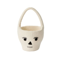 White felt basket with a cute skull face design on a white background