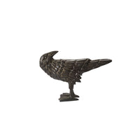 Bronze raven sculpture on a white background