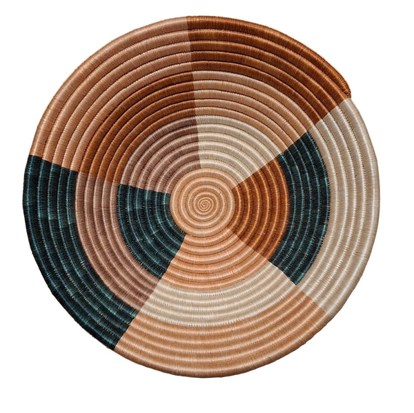 Round woven basket with concentric circle pattern on a white surface