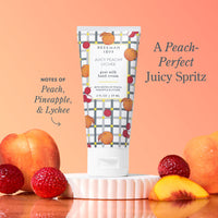 Beekman 1802 Juicy Peach Lychee hand cream with peach, pineapple, and lychee text on a peach background