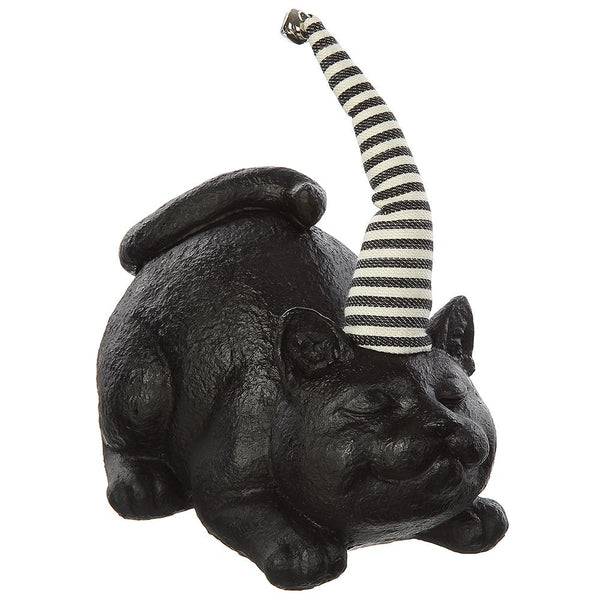 A black cat figurine lying down with its tail raised, wearing a black and white striped party hat, shown on a plain white background.