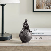 Brown Cast Iron Boy Reading on Globe Sculpture | Danya B.