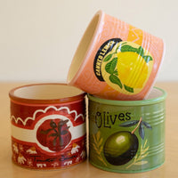 Three decorative vases with fruit-themed designs on a wooden surface.