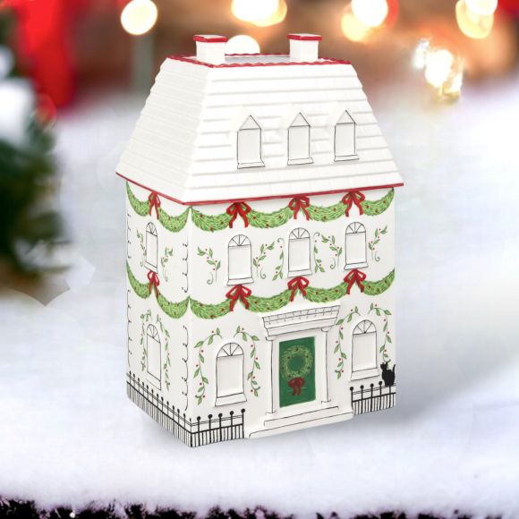 Decorative house-shaped box with Christmas designs on a snowy background