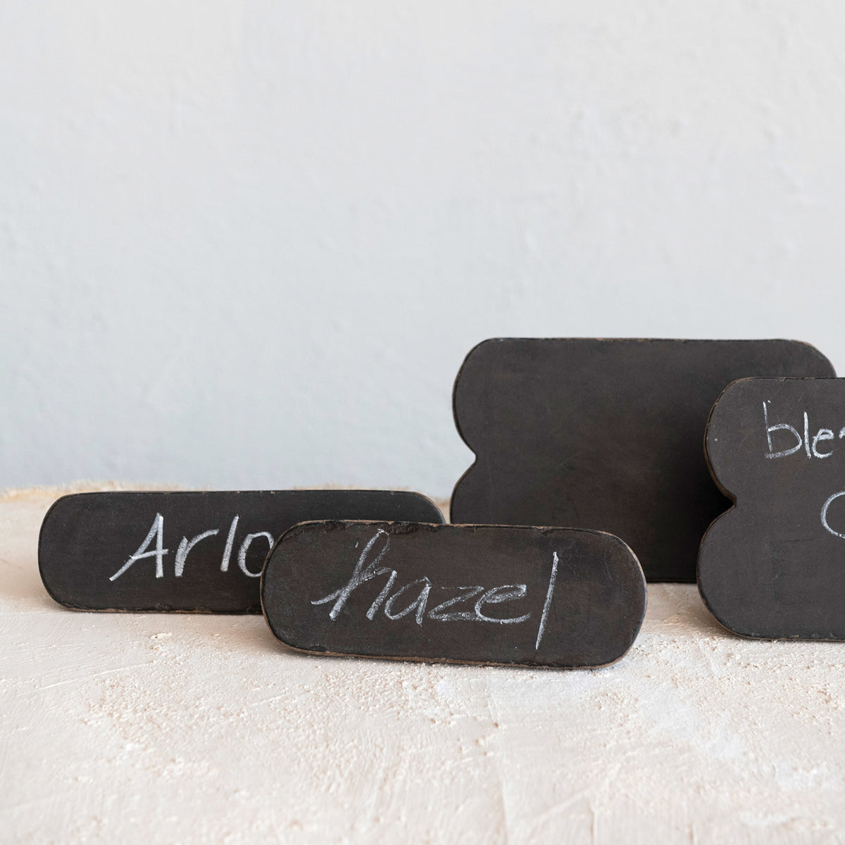 Black chalkboard signs with names 'Arlo' and 'Hazel' on a light background