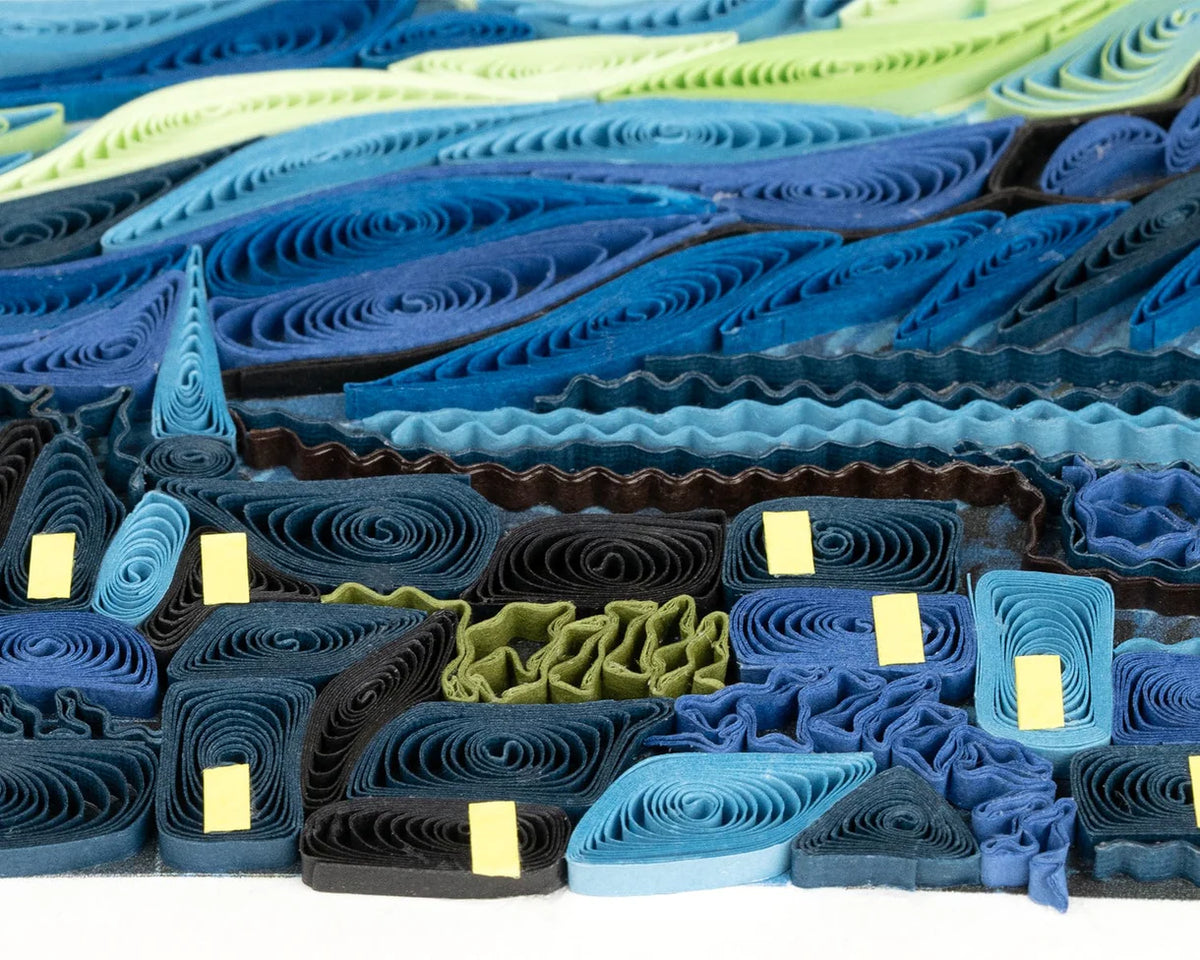 Close-up of a paper quilling 'Starry Night' art piece with blue, brown, and white colors.