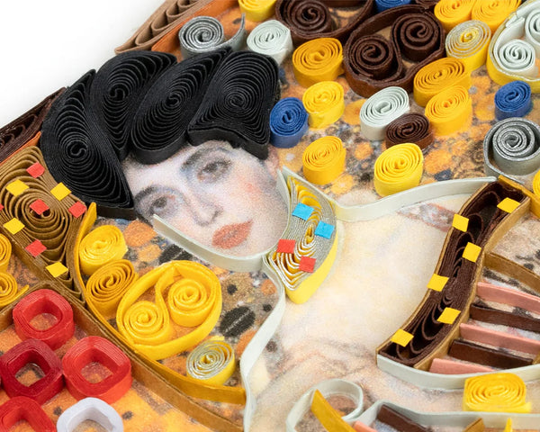 Close up of a quilled depiction 'Lady in Gold' face made from rolled paper in various colors.