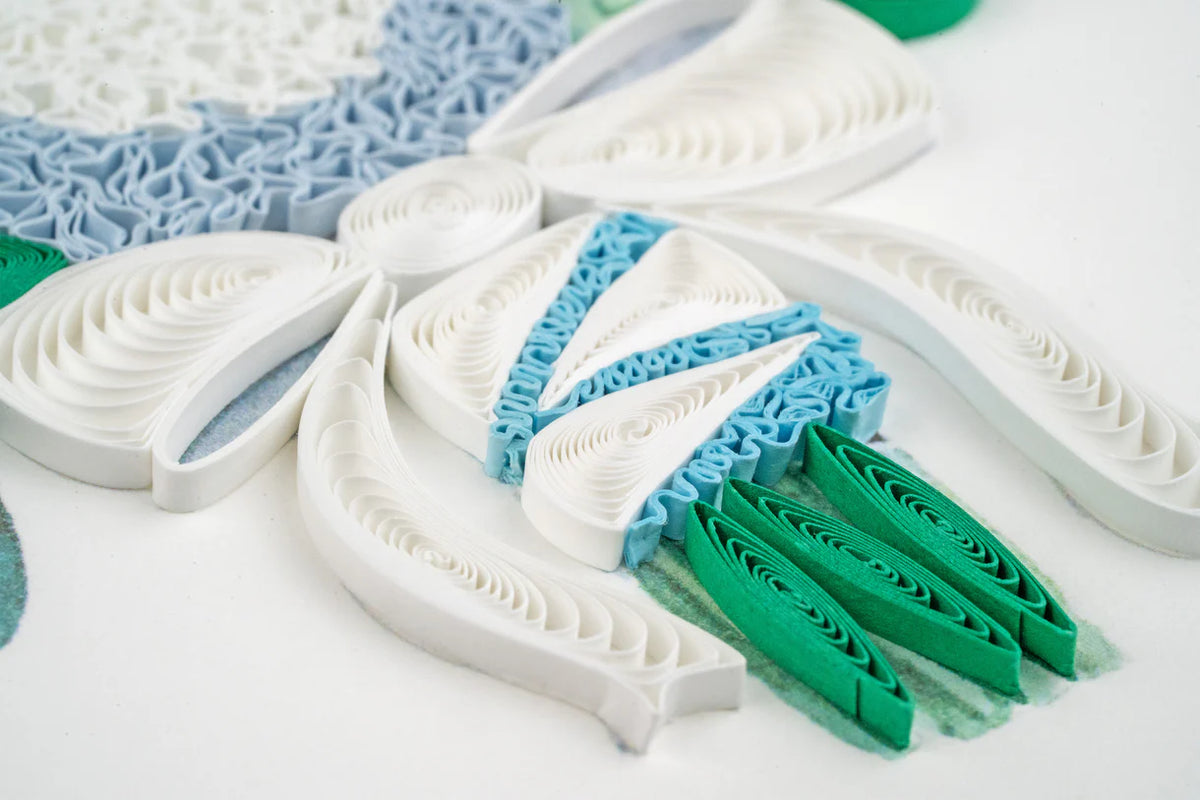 Close up of quilled greeting card featuring a bow around a bouquet of flowers.