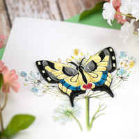 Colorful quilled swallowtail butterfly greeting card on a white background with flowers.