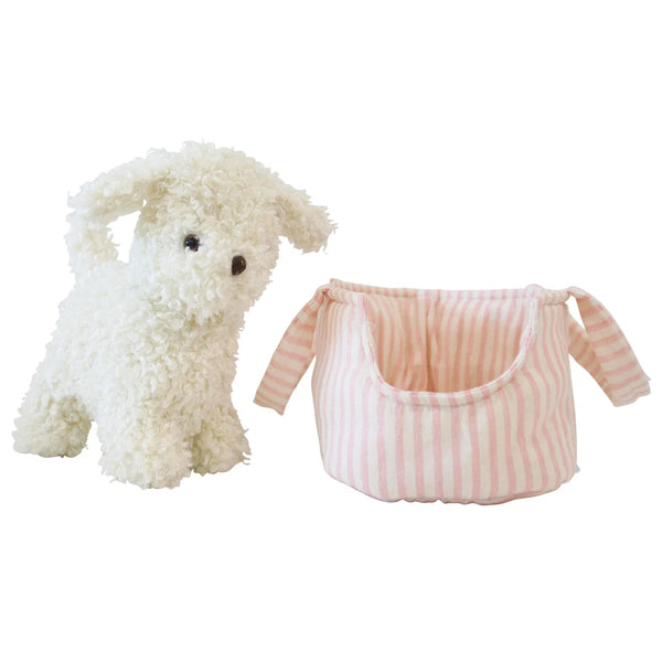 White plush dog toy next to a pink striped pet carrier on a white background