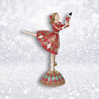 Decorative figurine of Clara from the Nutcracker play in a red dress on a white background