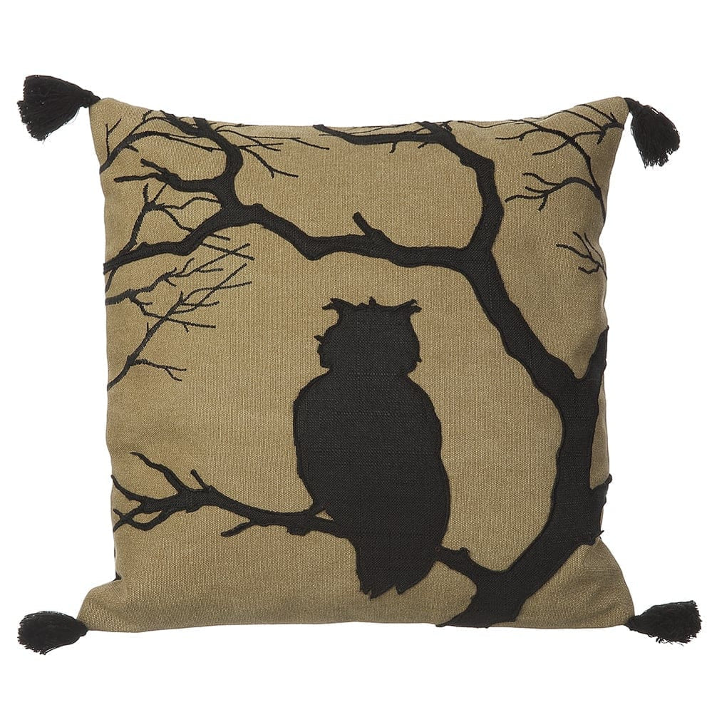 A square decorative throw pillow with a black owl silhouette and bare tree branches on a tan textured fabric background, finished with black tassels at the corners, shown on a plain white background.