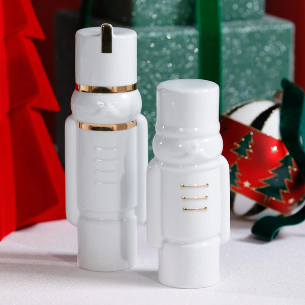 Two white soldier figurines with gold accents on a festive background.