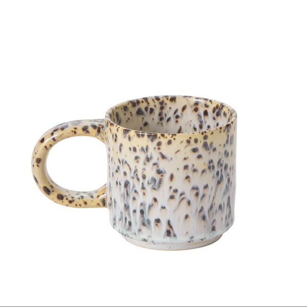 A tan coffee mug with a speckled appearance on a white background.