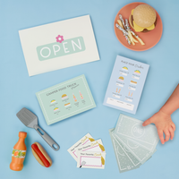 Children's playset with food truck-themed cards and toys on a blue background