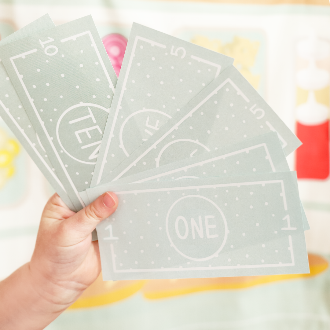 Child holding play money on a colorful background