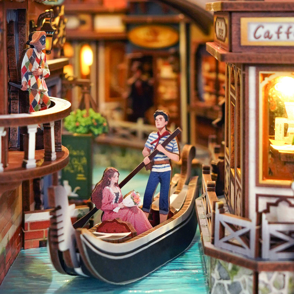 Miniature model of a gondola with figures on a detailed street scene.