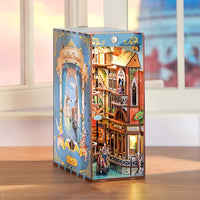 Boxed model kit of a detailed miniature house with a colorful design on a wooden surface.