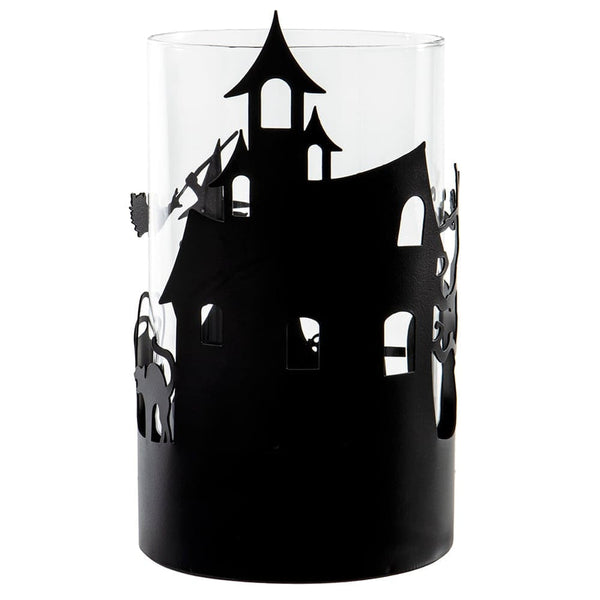 A clear cylindrical glass candle holder or vase featuring a black silhouette cutout of a haunted house with bats on the side, shown against a plain white background.