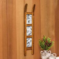 A rustic wooden ladder-shaped wall decor piece with three vertical panels showing black-and-white mountain and ski scenes, mounted on a warm wood-paneled wall beside a decorative vase with greenery and red berries.